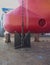 The bow of a large cargo ship with a bulb and a bow thruster on a slipway