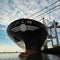 Bow of large ship in port at sunset.