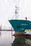 The bow of the ship at the shore on the embankment against the background of cranes vertical photo