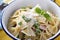 Bow ties pasta with ham and green peas