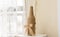 Bowknot on the artistic bottle on the table next to a window with white curtain. Home decoration concept