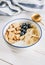 Bowl with amaranth corn pads with banana, blueberry and yogurt on white wooden background. Healthy breakfast and gluten free