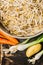 Bowl with bean sprouts and soybean sprouts with fresh organic vegetables on rustic wooden background