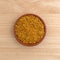 Bowl of bee pollen granules on a wood table