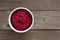 Bowl of beet hummus, above view on rustic wood