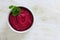 Bowl of beet hummus dip, above view on a white marble background