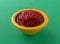 Bowl of beets and pears baby food on a green background