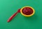 Bowl of beets and pears baby food with a spoon to the side on a green background