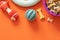 Bowl of bones for dogs on orange background. Close up. Accessories, rubber, textile toys for dogs.