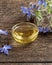 A bowl of borage oil with blooming starflower plant