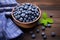 Bowl brimming with superfood Organic wild blueberries on wooden table