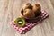 Bowl of bunch of kiwis and slice on a wooden table