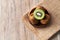 Bowl of bunch of kiwis and slice on a wooden table