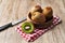 Bowl of bunch of kiwis and slice on a wooden table