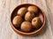 Bowl of bunch of kiwis on a wooden table