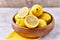 Bowl of bunch of lemons and halves on a marble surface