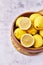 Bowl of bunch of lemons and halves on a marble surface