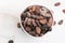 Bowl of cacao beans on a white background