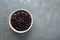 Bowl of canned kidney beans on grey table, top view. Space for text