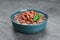 Bowl of canned kidney beans with parsley on grey table, closeup