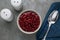 Bowl of canned kidney beans, spoon and shakers on grey table, flat lay