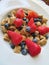 Bowl of cereal with fresh blueberries and strawberries for a nutritional breakfast