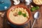Bowl of champignon mushroom cream soup puree with croutons and basil leaf
