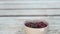 Bowl of cherries on the painted wooden porch steps with legs of a kid walking on the background