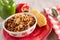 Bowl of Chili With Corn Bread Muffin And Peppers