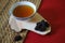 Bowl of chinese herb tea with jujubes on red background.