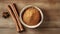 Bowl of cinnamon powder and sticks on wooden table. Flat lay