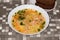 Bowl of clear trout soup on a table