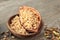 Bowl and cocoa pod with fresh tasty pine nuts on wooden table