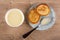 Bowl with condensed milk, milk in spoon, pancakes in blue saucer on table. Top view