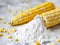 bowl with corn starch on kitchen table and ear of corn