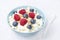 Bowl of cottage cheese with berries, honey, nuts for breakfast