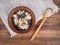 Bowl with dairy product cottage cheese, raisins and dried apricots near to the wooden spoon on old wood table and rough