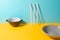 Bowl, deep plate and plastic straws on colorful background