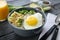 Bowl with delicious oatmeal, egg and avocado on wooden table