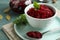 Bowl with delicious pickled beets on blue table, closeup