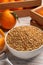 Bowl with dried orange seasoning zest and fruits on white wooden table, closeup