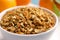 Bowl of dried orange zest seasoning and fresh fruits, closeup