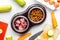 Bowl of dry dogfood, carrot, courgette and meat table background top view