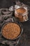 Bowl of dry raw buckwheat groats on a dark background. Cooking buckwheat porridge concept