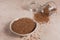 Bowl of dry raw buckwheat groats and glass jar on a light beige background. Cooking buckwheat porridge concept