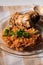 Bowl of east African Jollof Rice garnished with pieces of roasted chicken. Vertical photo