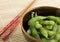 Bowl of edamame with chopsticks