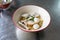 A bowl of egg noodle with variety of fish balls in Thai style on