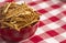 Bowl of Extra Thin Salted Stick Pretzels on a Red and White Table Cloth