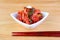 Bowl of Famous Korean Dish Kimchi with a Pair of Chopsticks on Wooden Table